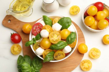 Taze salata, sarı domatesler, fesleğen ve mozzarella peyniri beyaz mermer masa, düz yatıyordu.