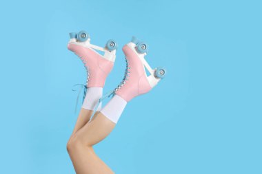 Açık mavi arka planda patenli bir kadın, yakın plan. Metin için boşluk