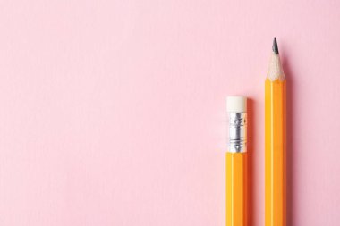 Pembe arka planda keskin grafit kalemler, üst manzara. Metin için boşluk