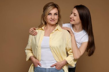 Kahverengi arka planda anne ve kızının portresi