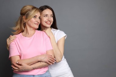 Gri arka planda anne ve kızının portresi. Metin için boşluk