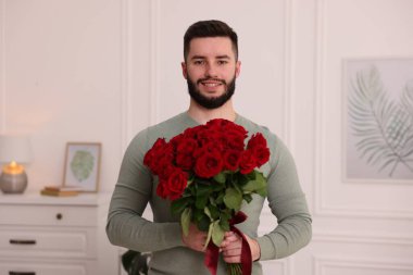 Evinde kırmızı gül buketi olan bir adam