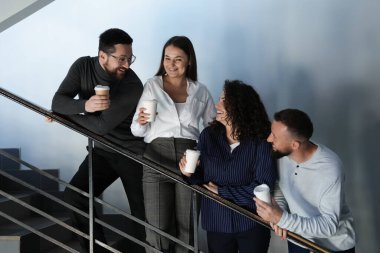 Mesai arkadaşları kahve molası sırasında ofislerinde kahve içerler.