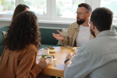 İş arkadaşları öğle arasında ofiste sohbet ediyorlar.