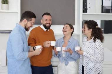 Ofiste kahve molası sırasında iş arkadaşları sohbet ediyor.