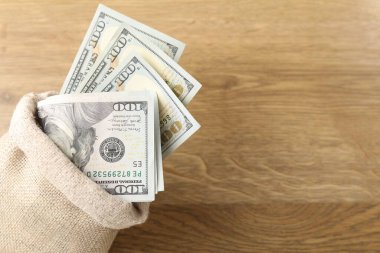 Tahta masada üzerinde dolar banknotları olan çanta, yakın plan. Metin için boşluk