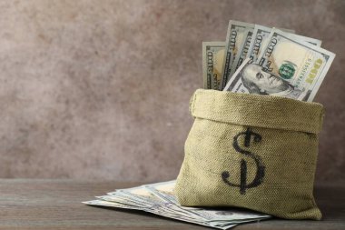Tahta masanın üzerinde dolar banknotları olan çanta, metin için yer