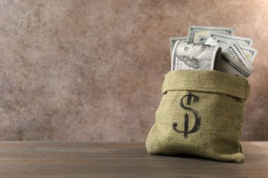 Tahta masanın üzerinde dolar banknotları olan çanta, metin için yer