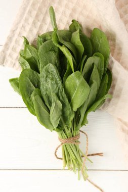 Beyaz ahşap masa üzerinde taze yeşil kuş yaprakları, üst manzara