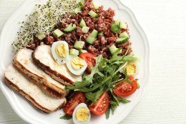 Beyaz ahşap masada kahverengi pirinçli nefis bir salata.