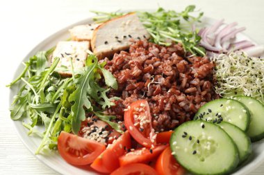 Beyaz ahşap masada kahverengi pirinçli leziz salata, yakın plan.