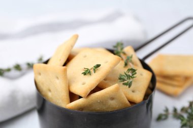 Lezzetli tuzlu krakerler ve kekik beyaz masada, yakın plan.