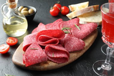 Siyah masada servis edilen biberiyeli lezzetli sosis dilimleri, yakın plan.