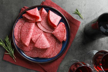 Gri masada servis edilen leziz sosis dilimleri.