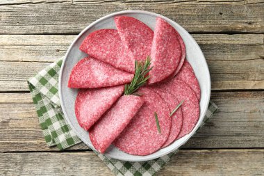 Ahşap masada servis edilen biberiyeli leziz sosis dilimleri.