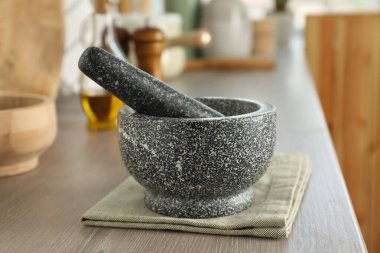 Mutfaktaki ahşap masada taş havan ve tokmak.