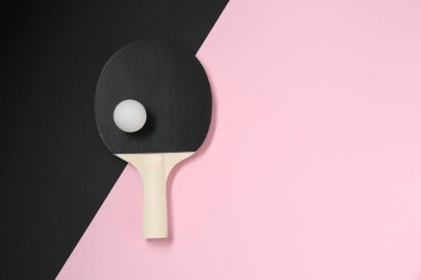 Renkli arka planda pinpon raketi ve top, üst görünüm. Metin için boşluk