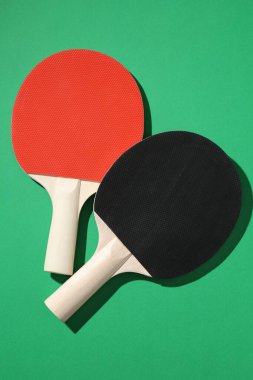 Yeşil arkaplanda pinpon raketleri, üst görünüm