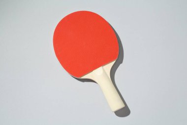 Açık arkaplanda bir ping pong raketi, üst görünümde.