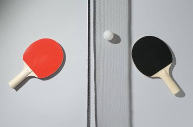 Ping pong raketleri, top ve net ışık arka planda, düz yatıyordu