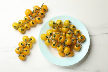 Olgun sarı domatesler beyaz mermer masada, düz yatıyordu.