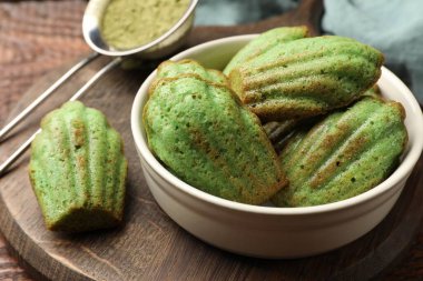 Lezzetli Matcha Madeleine kekleri ahşap masada, yakın plan.
