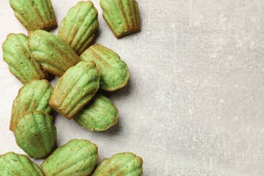 Matcha Madeleine kekleri ışık masasında, düz yerde. Metin için boşluk