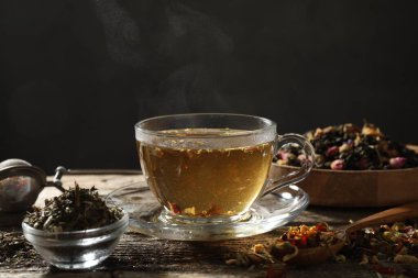 Bitki çayı ve kuru yaprakları ahşap masaya serpmek, yakın çekim. Metin için boşluk