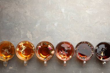 Aromatik bitki çayı, cam bardaklarda, gri masada, düz yerde. Metin için boşluk