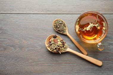 Cam bardakta Aromatik bitki çayı ve tahta masada kuru yapraklar. Metin için boşluk