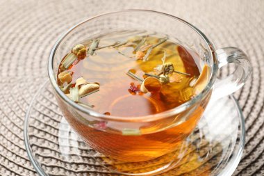 Paspasın üzerinde cam bardakta Aromatik bitki çayı, yakın plan.