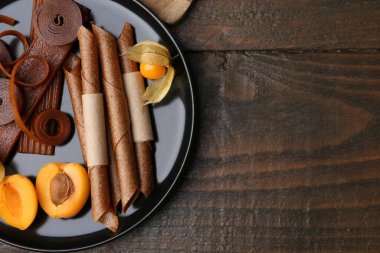 Lezzetli meyve derisi, bitki kökü ve kayısılar ahşap masada, üst manzara. Metin için boşluk