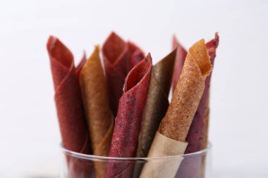 Beyaz arka planda lezzetli meyve dürümleri, yakın plan.