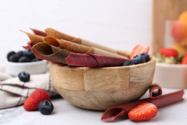 Lezzetli meyve dürümleri ve beyaz masada böğürtlenler, yakın plan.