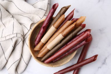 Lezzetli meyveler beyaz mermer masada yuvarlanıyor, düz yatıyordu.