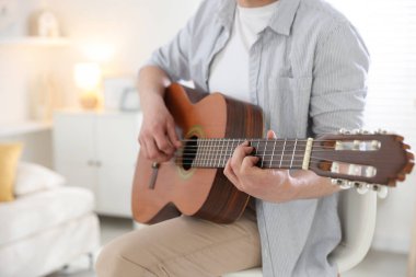 Evde gitar çalan adam, eline odaklan.