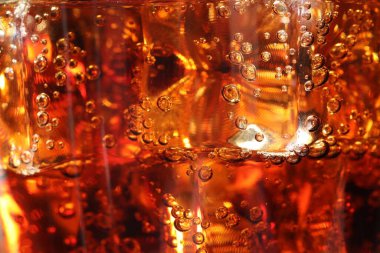 Arkaplan olarak buz küpleriyle kola tazeleniyor, makro görünüm