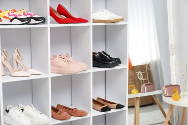 Ayakkabı deposu. İçeride bir sürü farklı ayakkabı bulunan raf ünitesi.