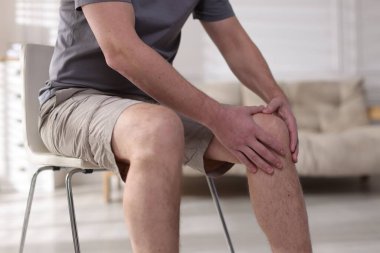 Evinde diz ağrısı çeken bir adam, yakın plan.