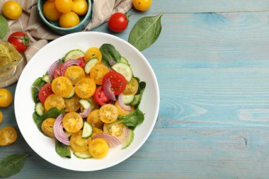 Açık mavi ahşap masada servis edilen yeşil domatesli taze salata. Metin için boşluk