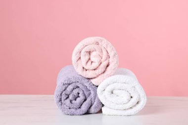 Pembe arka planda açık mermer masa üzerinde temiz havlular