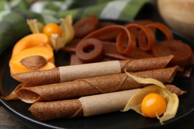 Lezzetli meyve derisi, bitki kökü ve kayısılar ahşap masada, yakın plan.