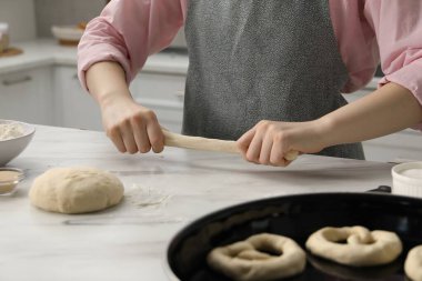 Mutfaktaki masada simit şekillendiren kadın, yakın plan.