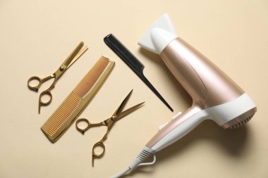 Bej arka planda taraklar, makas ve kurutma makinesi, düz konum