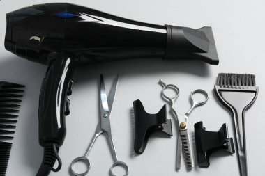 Beyaz arkaplanda farklı saç şekillendirme araçları, yakın plan