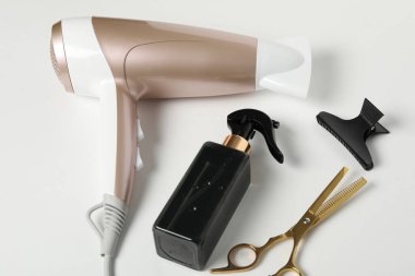 Beyaz arkaplanda farklı saç şekillendirme araçları, yakın plan