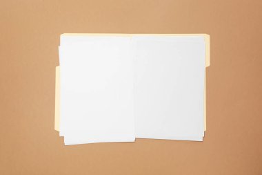 Açık kahverengi arkaplan üzerinde boş sayfaları olan kağıt dosya dizini, üst görünüm