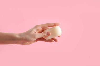 Açık pembe arka planda sabun çubuğu olan kadın, yakın plan.