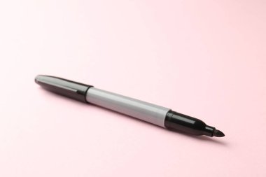 Açık pembe arka planda bir siyah işaret, yakın plan. Metin için boşluk