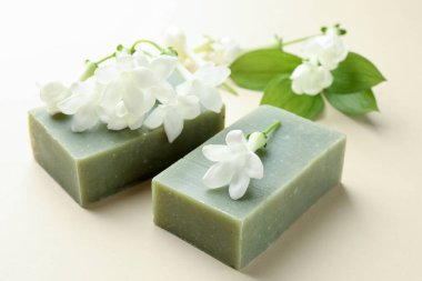 Bej arkaplanda sabun ve yasemin çiçekleri, yakın plan.